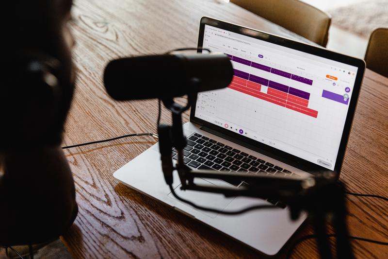 Open laptop with a podcasting microphone in foreground